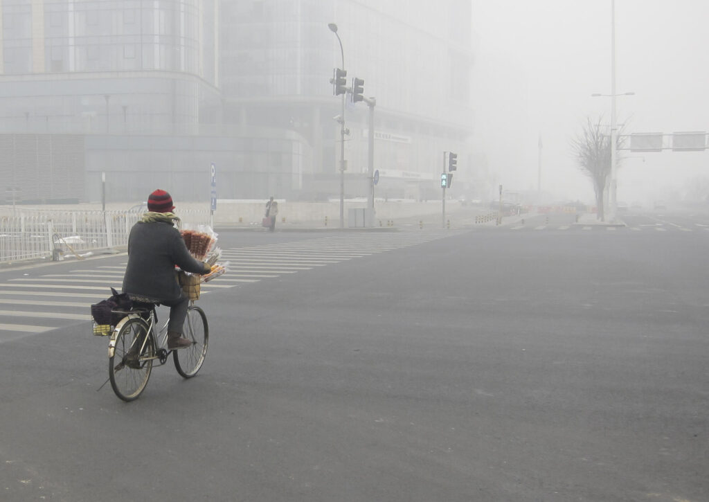 Photo of someone biking into smog.