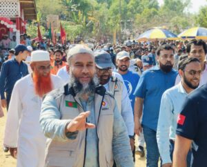 Abu Saleh Mohammad Obaidullah walks in a crowd of people with his arm stretched out