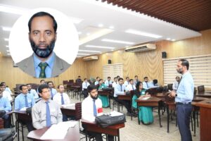 Razibul Islam stands in front of a classroom of students